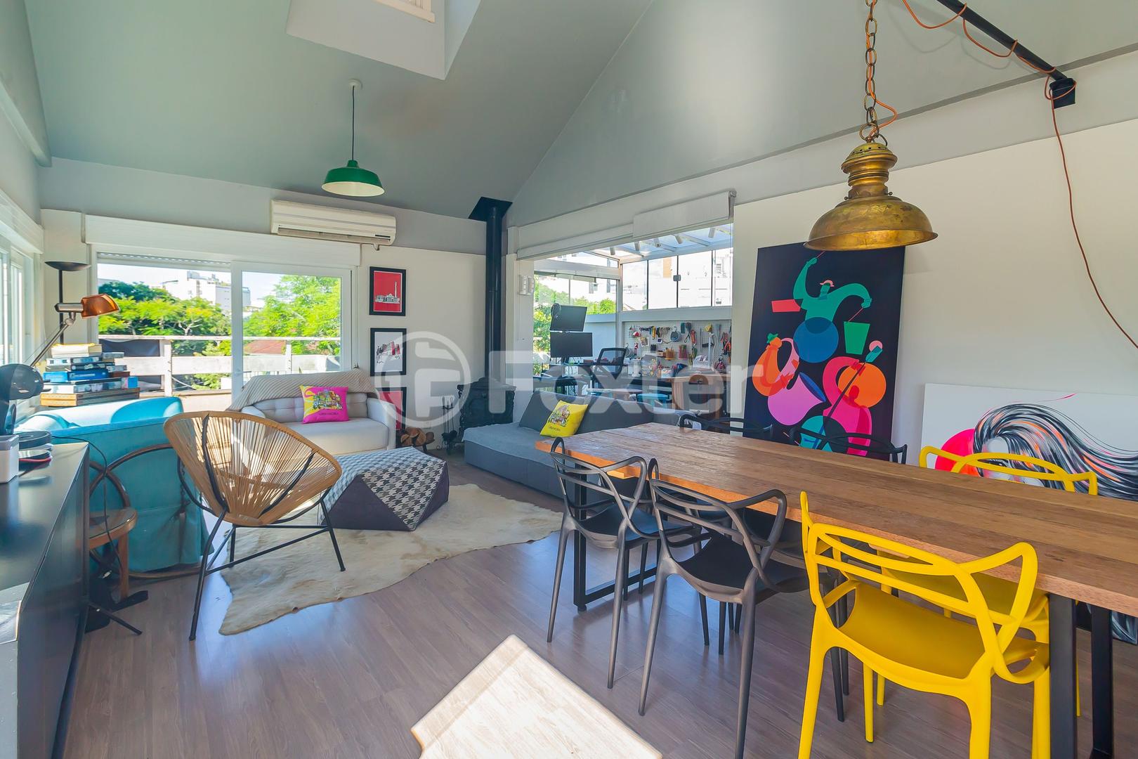 Loft com pé-direito alto, mesa de madeira e janelas